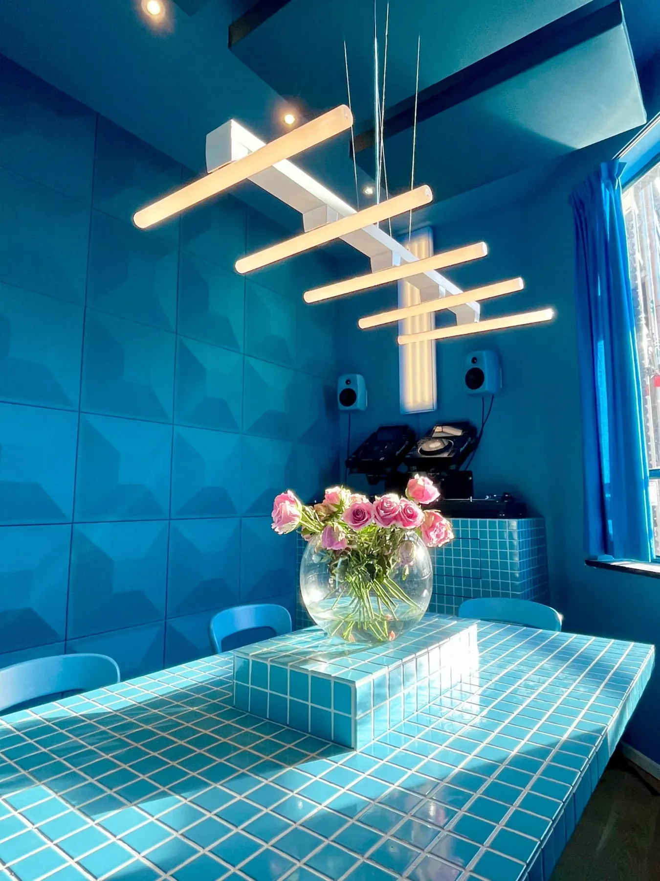 Blauwe ruimte met tafel en hangende lichtobjecten