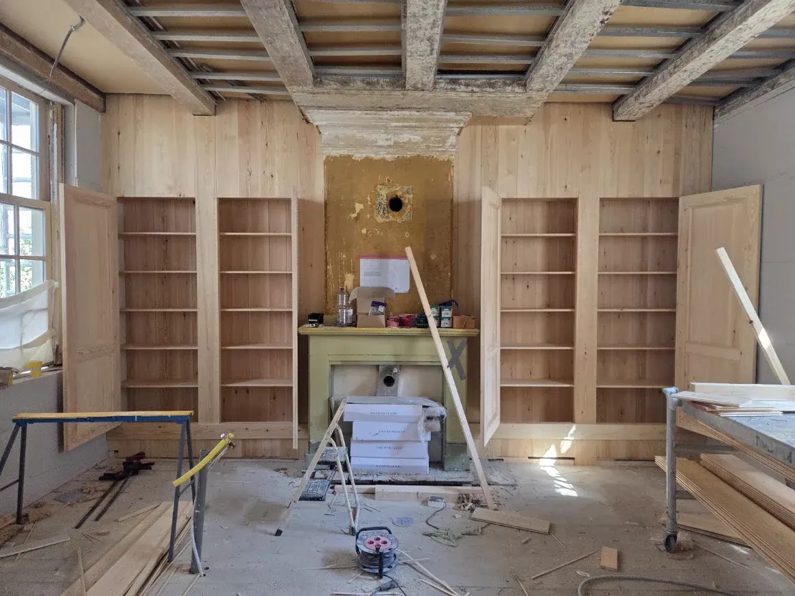 Kastenwand tijdens plaatsing in een hoge ruimte met balkenplafond